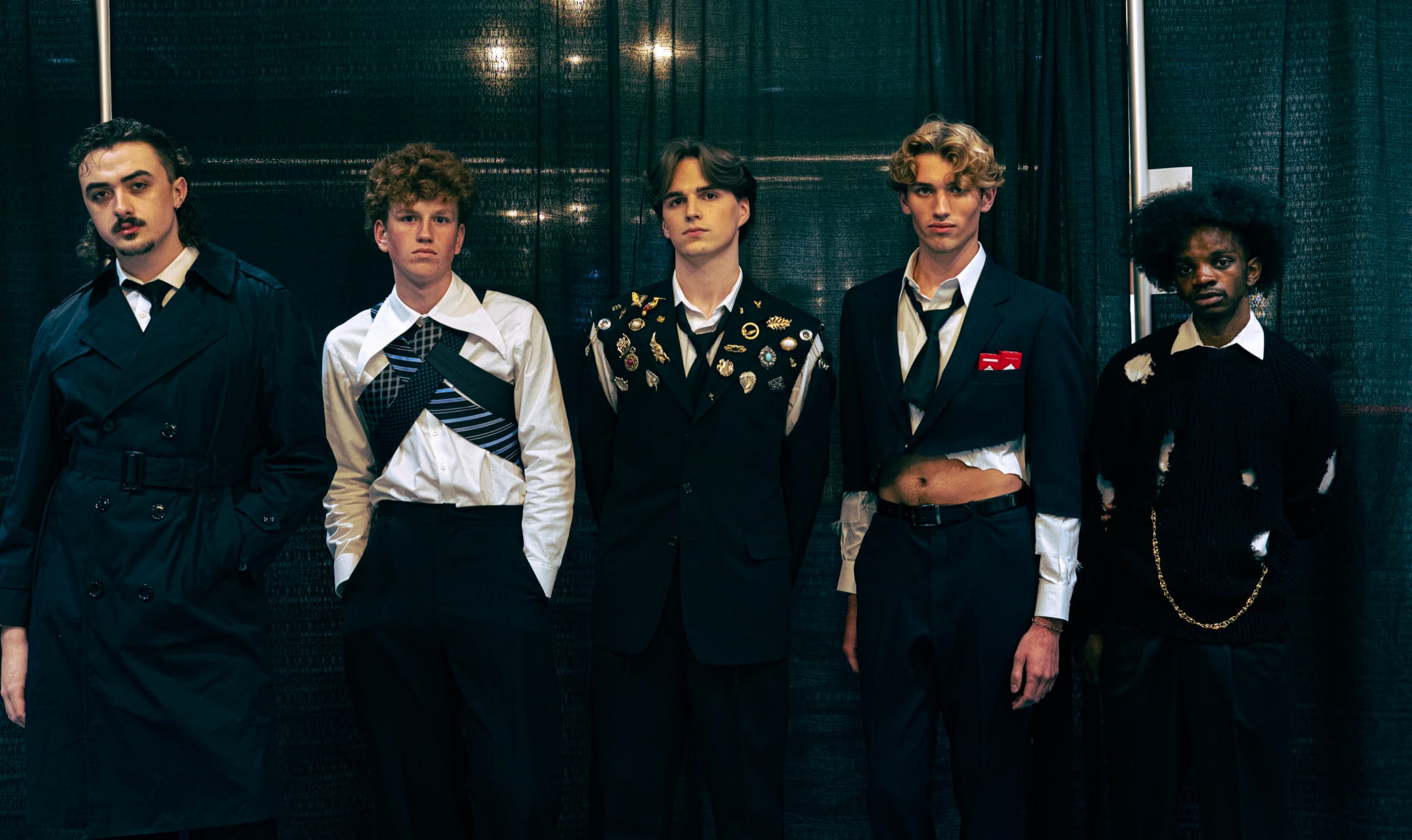 Five models in the finished 1975 line, in black tailoring and loosened ties, backstage